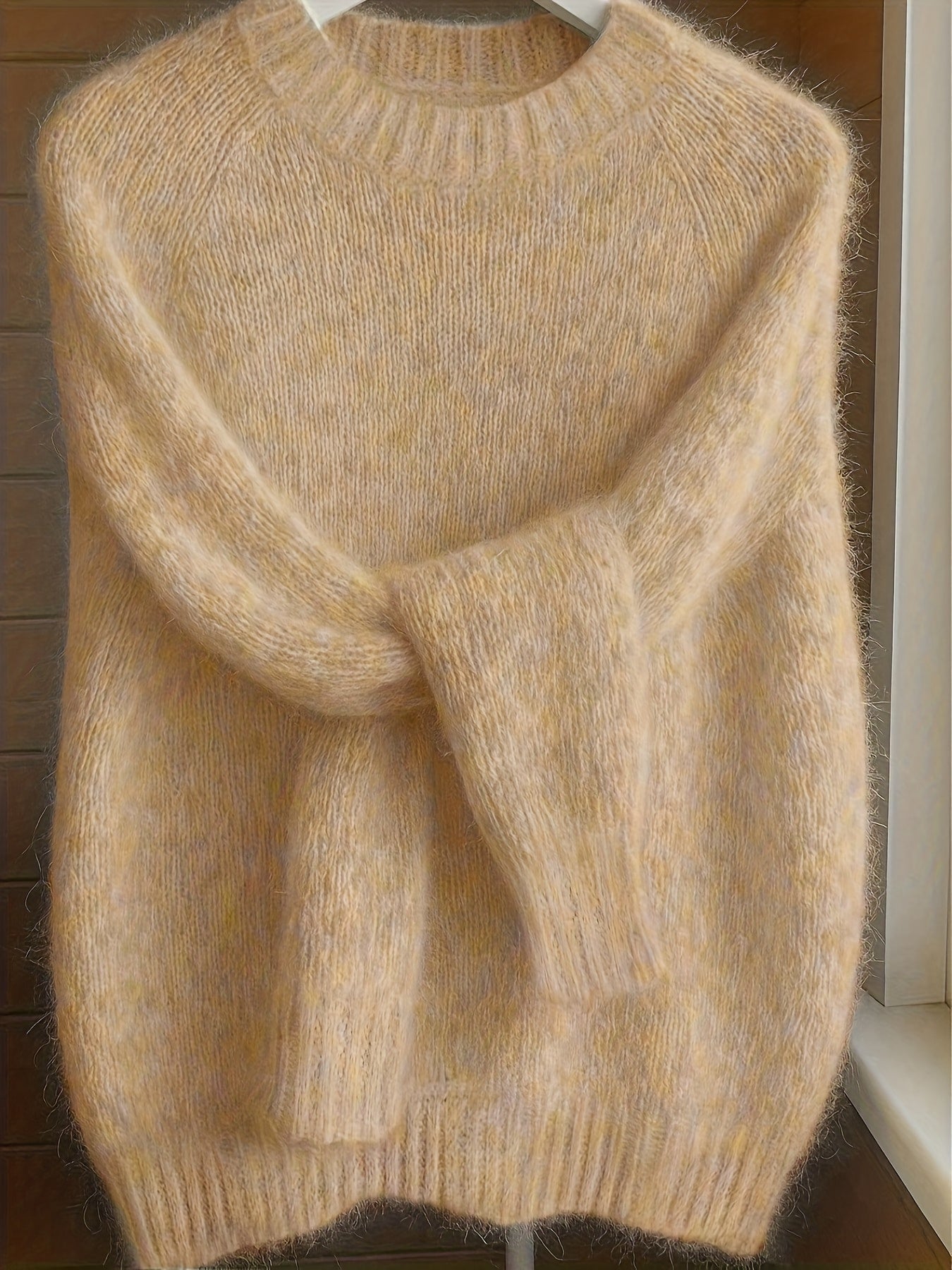 Front view of the Elara cashmere-blend sweater in a soft apricot color, showcasing its relaxed fit.