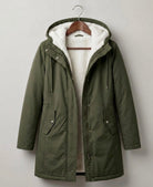 Lifestyle shot of someone walking in a park during light rain, comfortably wearing the Elara waterproof parka.