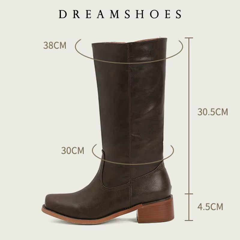 Elara classic Western boots in dark brown, showcased in an outdoor setting, complementing an autumn-inspired outfit.
