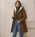 Model in the Elara parka adjusting the hood, illustrating its functional and snug fit.