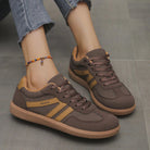 A woman's feet in leopard print Elara orthopaedic cushioned trainers, styled with casual jeans.