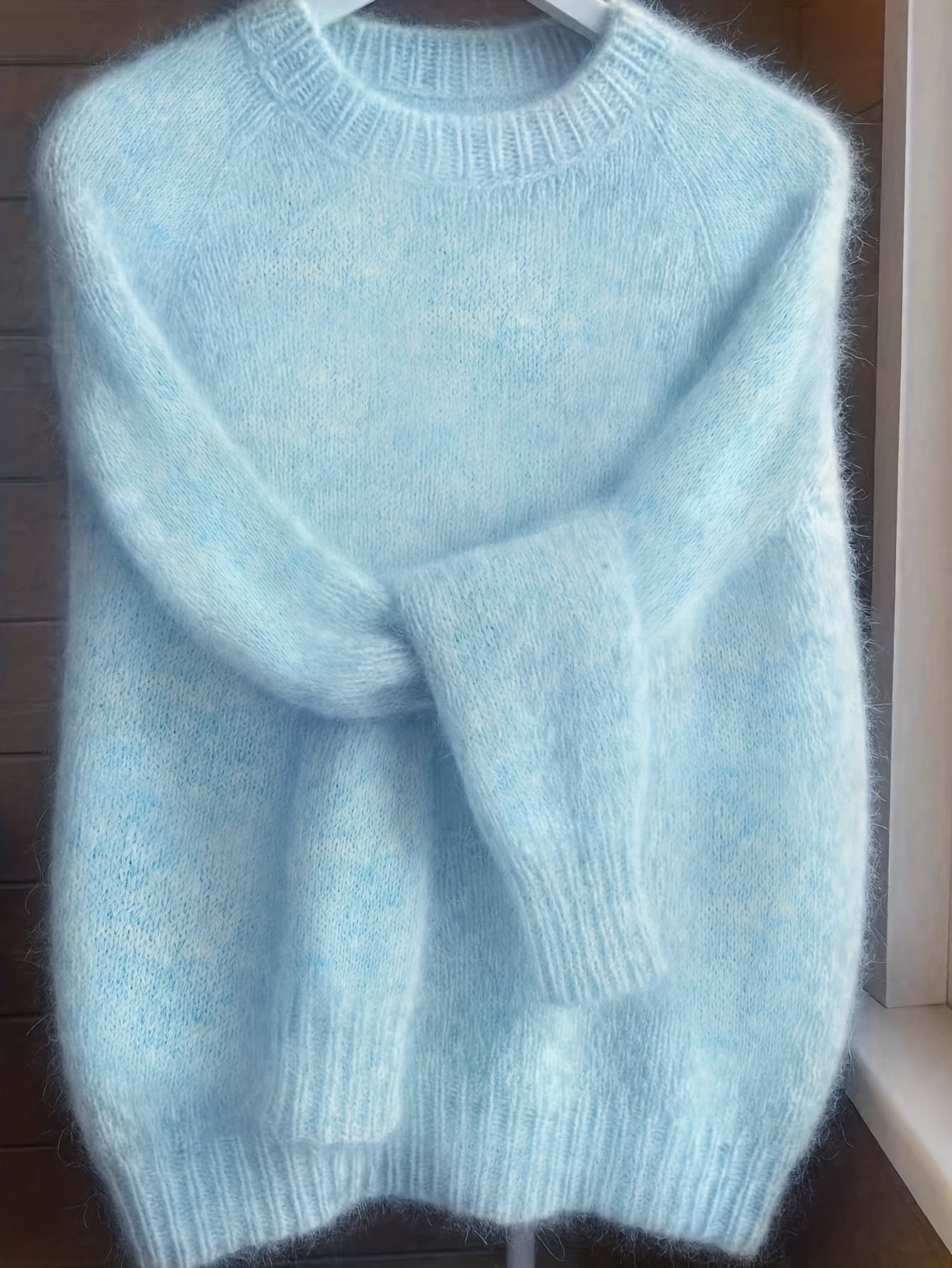 Detail shot of the cuff and sleeve of the Elara cashmere-blend sweater in blue, emphasizing the soft material.