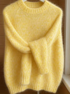 Lifestyle image of a woman comfortably wearing the Elara cashmere-blend sweater while reading a book indoors.