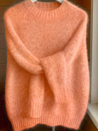 Flat lay of the Elara cashmere-blend sweater in white, neatly folded to show its premium material and color.