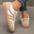 Arrangement of off-white and black Elara orthopaedic cushioned trainers side by side, showcasing color options.