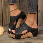 Elysia studded platform wedges in classic black, showcasing the elegant studded strap design from a front angle.