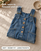 Side profile of the utility jumpsuit, highlighting its large pockets and wide leg silhouette.