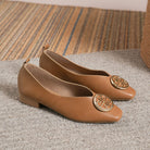 Overhead shot of green square-toe flats on a light background, emphasizing the sleek upper material.
