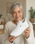 Holding the white Clover sneaker