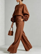 Folded pair of elegant wide-leg trousers, displaying the wide hem and relaxed cut.