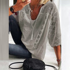 Side profile of a women's three-quarter sleeve blouse, showcasing its loose drape and comfortable silhouette.