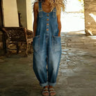 Side profile of a woman wearing Juniper relaxed fit denim overalls, highlighting the flattering drape and easy movement.