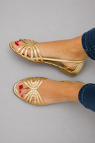 Pair of Kaelen vintage sandals in gold color, showcasing the elegant golden strap detail from a top-down view.