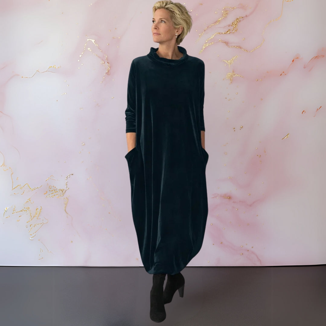 Front view of a woman wearing the dark green Katiya velvet maxi dress, showcasing its elegant draped silhouette.