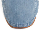Man adjusting the Kian classic denim flat cap, capturing its ease of wear and versatile appeal.