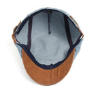 Kian classic denim flat cap placed on a wooden surface, showing its texture and casual elegance.