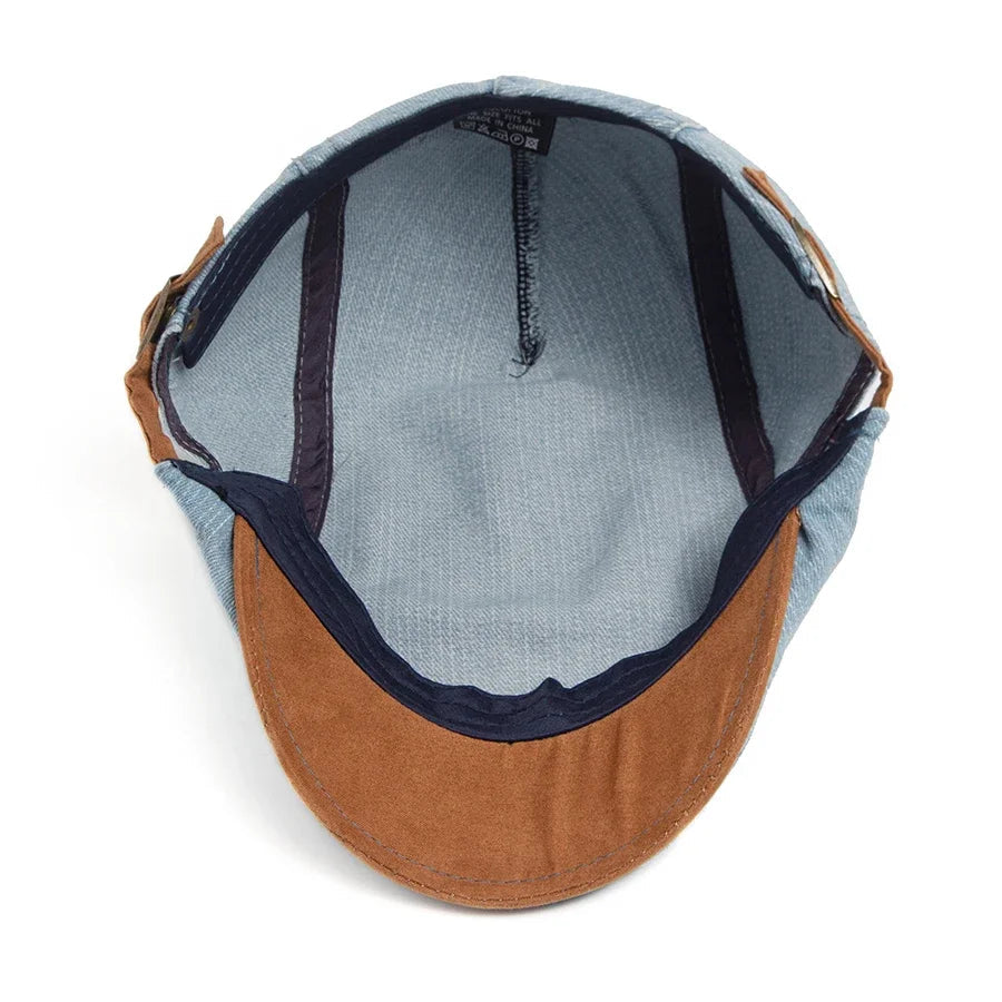 Kian classic denim flat cap placed on a wooden surface, showing its texture and casual elegance.
