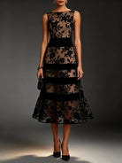Close-up detail of the intricate floral embroidery on the bodice of the sophisticated black tulle midi dress.
