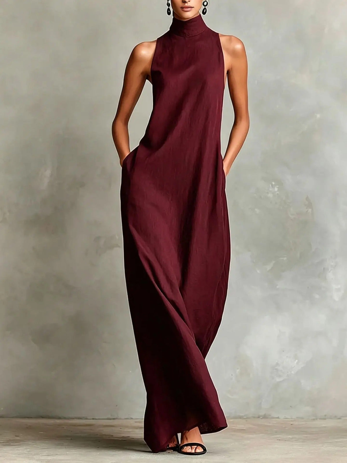 Lifestyle shot of a woman enjoying an outdoor gathering in a black sleeveless maxi dress, exuding quiet sophistication.