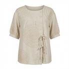 Close-up detail of the raised circular embroidery on the Mirabelle casual top's fabric surface.