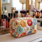Noelle handmade quilted cosmetic bag with brilliant petals print, shown open to reveal interior, on a light surface.