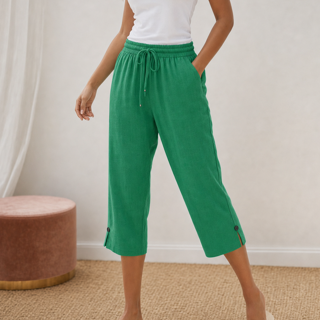 Woman wearing blue cotton-linen capri trousers styled with a casual white top and sandals.