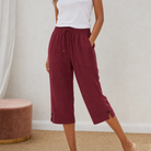 Elegant styling of black capri trousers with a linen blouse, suitable for evening wear.