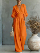 Detailed shot of the subtly integrated pockets on a stylish orange jumpsuit, adding practicality.