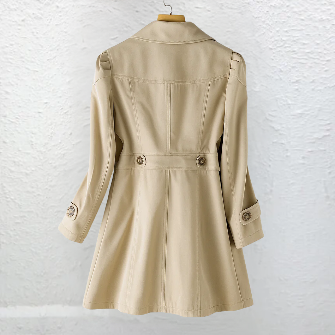 A woman sitting casually, wearing the Renata summer trench coat, illustrating its comfort and versatility for everyday wear.