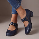 Detailed view of the adjustable buckle strap closure on a navy blue orthopaedic Mary Jane shoe, emphasizing secure fit.