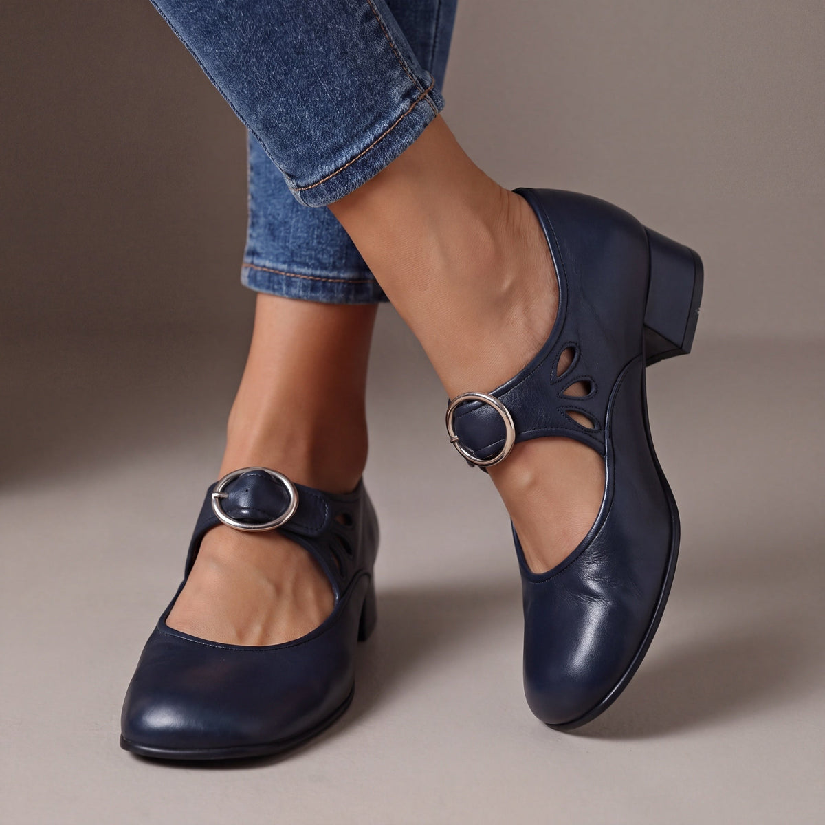 Detailed view of the adjustable buckle strap closure on a navy blue orthopaedic Mary Jane shoe, emphasizing secure fit.