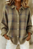 Woman comfortably seated, wearing the orange Sable relaxed fit cardigan, illustrating its comfort.