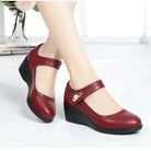 Detailed view of the adjustable strap and buckle on a red Elara mid-heel shoe, showing the secure and customizable fit.