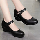 A woman wearing black Elara mid-heel shoes, walking on a paved surface, illustrating their comfort and versatility.