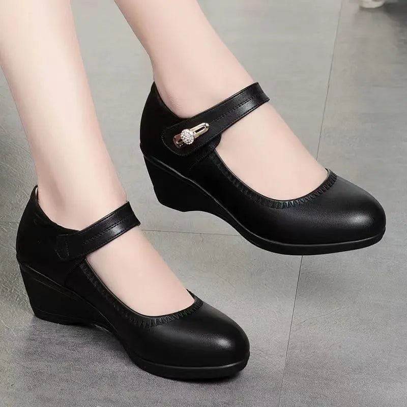 A woman wearing black Elara mid-heel shoes, walking on a paved surface, illustrating their comfort and versatility.