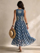 Woman walking in the Soraya denim and chiffon midi dress, demonstrating the graceful flow of the polka-dot skirt.