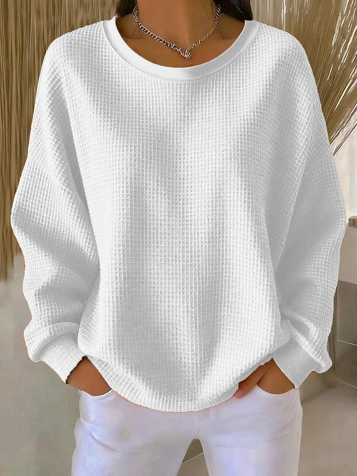 Model in a studio setting, posing in a vibrant colored Soraya knitted wide collar sweater, full length shot.