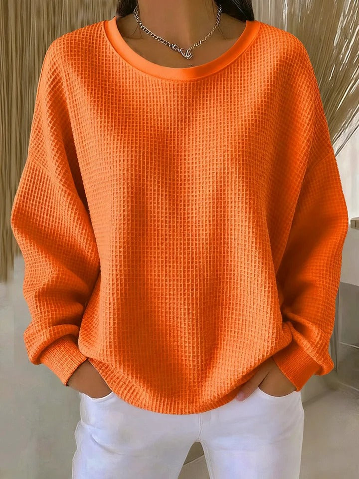 Woman walking outdoors, styled casually in the Soraya knitted wide collar sweater, in a practical context.