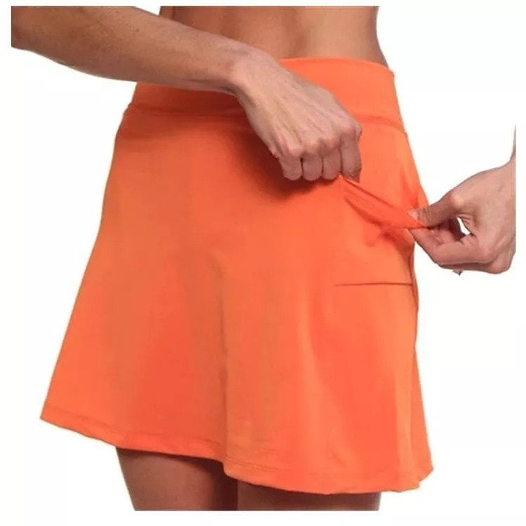 Dynamic action shot of a woman jogging in a purple active skort, demonstrating freedom of movement.