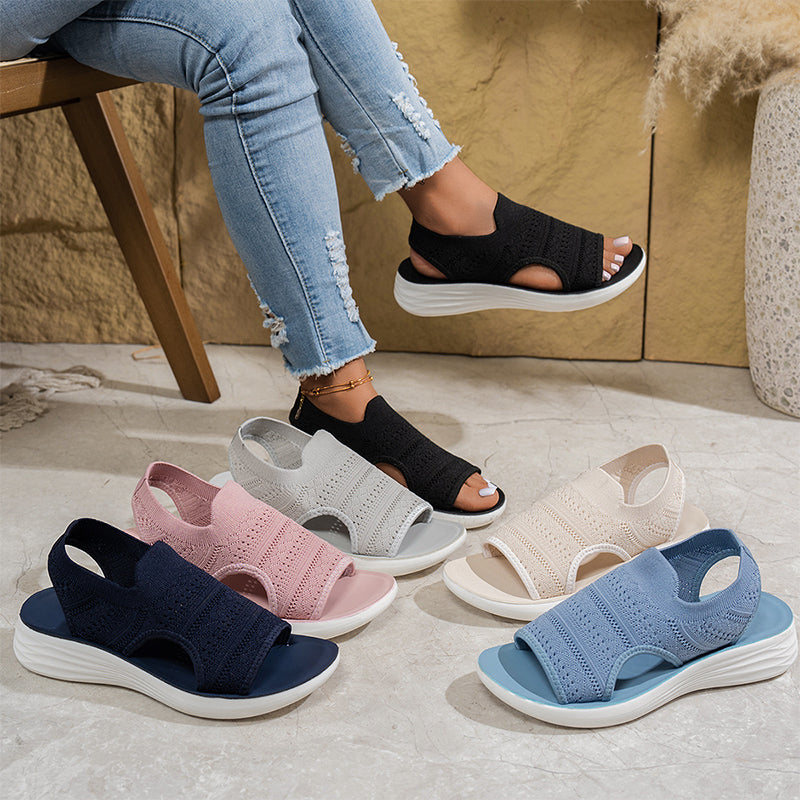 The flexible sole bending on a pair of dark blue breathable sandals, demonstrating freedom of movement.