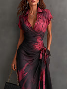Side profile of the flowing blue abstract print maxi dress, showcasing the ruffled high-low hem.